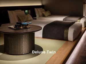 a hotel room with two beds and a table with a table at Mitsui Garden Hotel Ginza-gochome in Tokyo