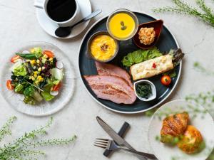 a table with plates of food and a cup of coffee at Mitsui Garden Hotel Ginza-gochome in Tokyo