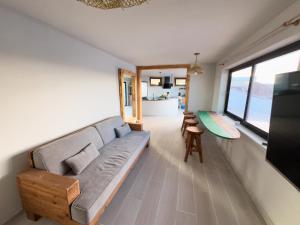 カレタ・デ・ファマラにあるBungalow Ahul Famara con pequeña piscinaのソファとテーブルのあるリビングルーム