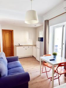 a living room with a blue couch and a table at El Jardin BeNerja in Nerja