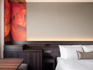 a hotel room with a bed and a table and a picture at Mitsui Garden Hotel Ginza-gochome in Tokyo