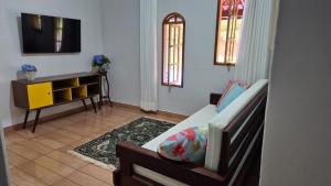 a living room with a couch and a tv at Casa Bourguignon in Vítor Hugo