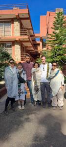 Un grupo de personas de pie frente a una casa en Zan-Seyoum Hotel - Lalibela, en Lalibela