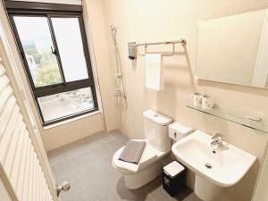 un bagno con un water, un lavandino e una finestra di 阿郎衝浪旅店A-lang Surfing House a Manzhou