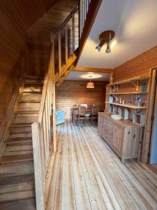 a room with wooden floors and a staircase in a cabin at La Farandole, coastal family home in Agon Coutainville