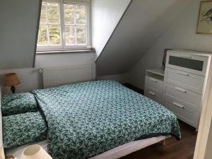 a bedroom with a bed and a dresser and a window at La Farandole, coastal family home in Agon Coutainville