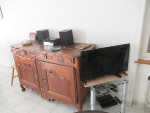 a wooden entertainment center with a television and speakers at La Farandole, coastal family home in Agon Coutainville