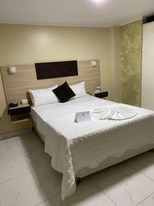 ChepénHotel Jose Ignacio Chepen的一间卧室配有一张大床,上面有书