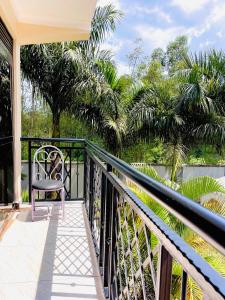 a balcony with a chair and a view of the water at Rafah Apartment in Namugongo