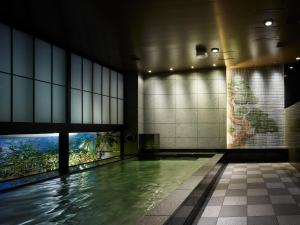 a swimming pool in a building with a painting on the wall at Mitsui Garden Hotel Ginza-gochome in Tokyo