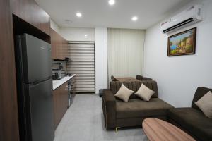 a living room with a couch and a kitchen at Mantra Sky Motel in Erbil
