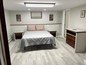 a bedroom with a bed and two dressers in it at Stony Fork Inn in Wellsboro