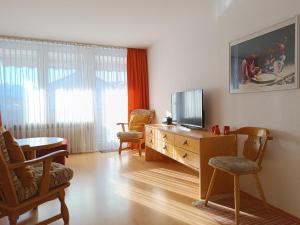 a living room with a television on a wooden dresser at 2-Raum FeWo Hüttenzauber - Hallenbad & Sauna in Fischen