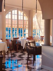 a dining room with tables and chairs and windows at Hôtel particulier des Jasmins in Le Bar-sur-Loup