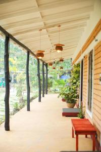 eine Veranda eines Hauses mit einer Bank und Bäumen in der Unterkunft Suji River Villa in Weligama
