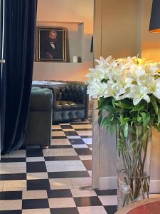 a living room with a couch and a vase of flowers at Hôtel particulier des Jasmins in Le Bar-sur-Loup