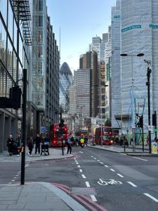 a busy city street with double decker buses and buildings at Small En-suite Shoreditch in London