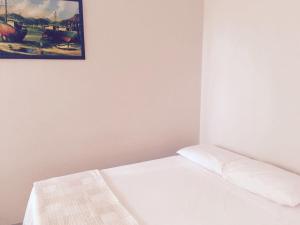 a white bed in a room with a picture on the wall at Cerrado Gran Hotel in Rio Verde