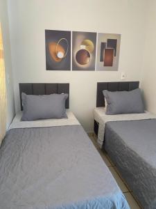 two beds in a room with paintings on the wall at Cerrado Gran Hotel in Rio Verde +9 photos