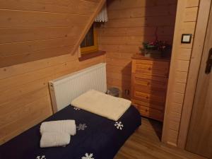 Un dormitorio con una cama en una cabaña de madera. en Domek do wynajęcia - Podczerwone, en Koniówka 31 fotos más
