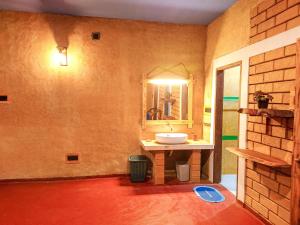 ein Badezimmer mit Waschbecken und Spiegel in der Unterkunft Suji River Villa in Weligama