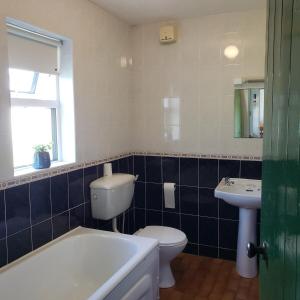 Heather Cottage 3 Bedroom في لويسبورغ: حمام مع حوض استحمام ومرحاض ومغسلة