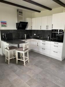 a kitchen with white cabinets and a table and chairs at Ferienhaus am Schwielochsee in Friedland