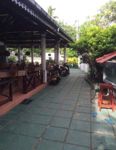 a patio of a restaurant with motorcycles parked underneath it at New Imperial Hotel in Hikkaduwa