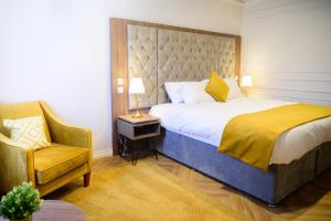 a hotel room with a bed and a chair at Walton View Hotel in Drighlington