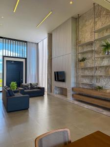 a living room with two couches and a tv at Casa Maravilhosa Cond Riviera Xangrila in Xangri-lá