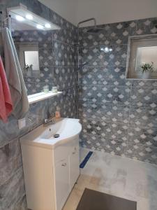 a bathroom with a sink and a shower at Ánizs Apartmanház in Makó +33 photos