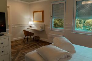 a bedroom with two beds and a table and a mirror at Locanda Gaudemus Boutique Hotel in Sistiana