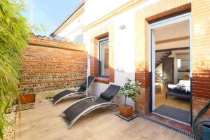 a patio with two chairs and a brick wall at NEW- L'Occitane-Maison toulousaine-Centre-Terrasse in Toulouse