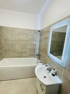 a bathroom with a sink and a bath tub and a white sink at Gold House in Bucharest