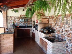 a kitchen with brick walls and a counter with pots and pans at Chácara Alto Padrão em Igaratá in Igaratá