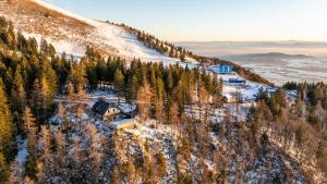 eine Luftaufnahme eines Hauses auf einem schneebedeckten Berg in der Unterkunft Vila Klif vacation home with sauna and terrace in Cerklje na Gorenjskem