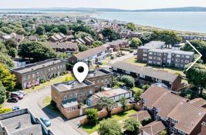 an image of a suburb with a white arrow pointing to a building at 3 bedroom-house -3mins to beach- PetsOk in Lymington
