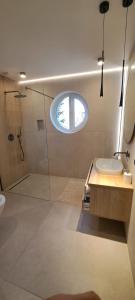 ein Badezimmer mit Waschbecken und Dusche mit Fenster in der Unterkunft SOSNOWA 23 in Tenczynek + 6 Fotos