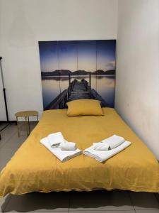 una camera da letto con un letto e asciugamani su un molo di Casa Lele a Gela Altre 23 foto