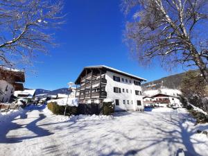 un bâtiment dans la neige sur une rue enneigée dans l'établissement Susis Apartment Altenmarkt, à Altenmarkt im Pongau