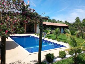 a swimming pool in front of a house at Chácara Alto Padrão em Igaratá in Igaratá