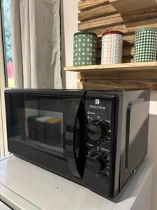 un forno a microonde nero seduto sopra un bancone di Casa Lele a Gela