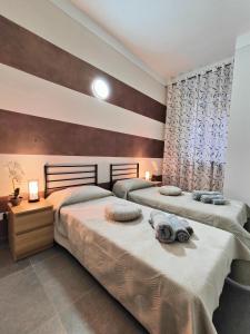 two beds in a bedroom with two lamps on them at Central Station Apartments - Managed by Silvio in Vercelli
