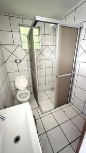 a white bathroom with a toilet and a shower at Pousada Altos dos Ingleses II in Florianópolis +63 photos