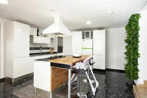 a kitchen with white cabinets and a wooden counter top at Charming Villa in Linares with Private Pool in Jaén