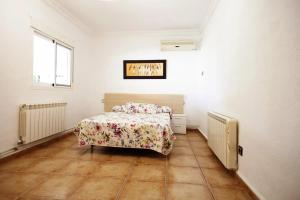 a bedroom with a bed with a floral bedspread at Charming Villa in Linares with Private Pool in Jaén