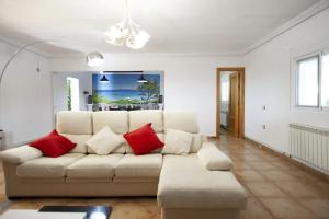 a living room with a white couch and red pillows at Charming Villa in Linares with Private Pool in Jaén