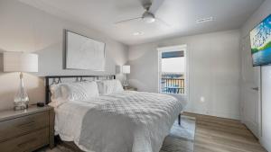 a white bedroom with a bed and a window at Luxury Apartment on the Strip! in Lake Ozark