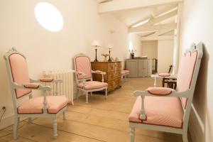a waiting room with pink chairs and a table at Château du Tertre in Arsac