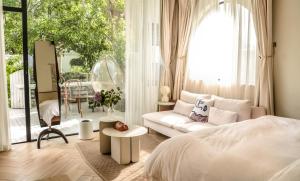 a bedroom with a white bed and a large window at 不觉晓花园民宿 in Shanghai